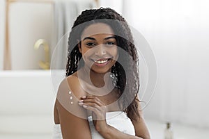 Beautiful Young Black Female Applying Moisturising Cream On Body After Bath