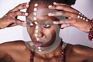 Beautiful black girl with faceart touchs her face photo