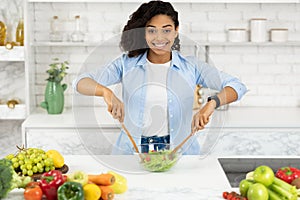 Beautiful young black girl preparing vegetable salad