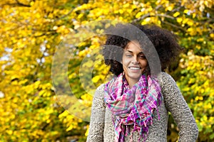 Beautiful young black woman with curly hair smiling outdoors