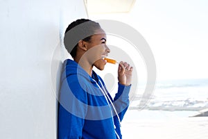 Beautiful young black woman eating ice cream outside