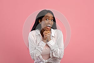 Beautiful young black woman expressing excitement or surprise on pink studio background