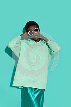 Beautiful young black woman in green neon color hoodie and sunglasses