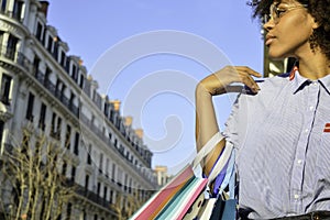 Beautiful young black woman holding shopping bags. Concept about shopping, lifestyle and people