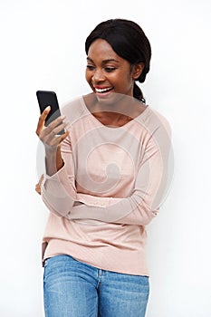 Beautiful young black woman laughing with cellphone against white background