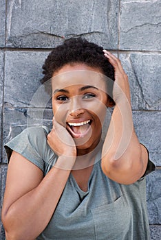 Beautiful young black woman laughing with hands to face