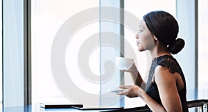 Beautiful young black woman looking thoughtfully out a large window