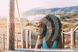 Beautiful young black woman lying down in a wooden foot bridge