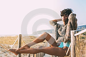 Beautiful young black woman sitting in a wooden foot bridge at