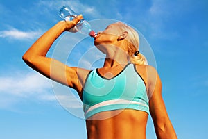 Beautiful young blond girl drinking water