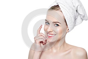 Beautiful Young Blond Woman applying Face cream under her eyes. Facial treatment.