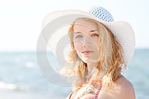 Beautiful young blond woman with beach hat