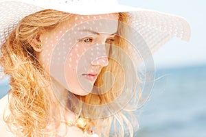 Beautiful young blond woman with beach hat