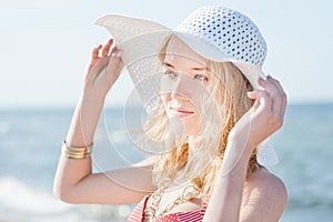 Beautiful young blond woman with beach hat