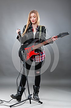 Beautiful young,blond woman with a electric guitar