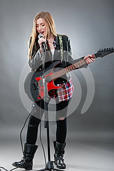 Beautiful young,blond woman with a electric guitar