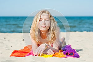 Beautiful young blond woman lying on a beach