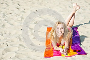 Beautiful young blond woman lying on a beach