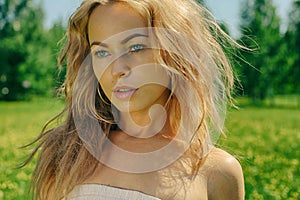 Beautiful young blond woman outdoors. Sunny day. Nature summer background