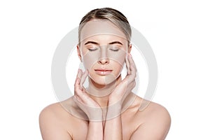 Beautiful Young Blond Woman with Perfect Skin touching her face. Facial treatment. Cosmetology, beauty and spa concept.