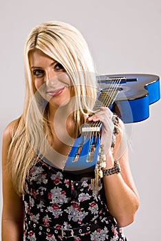 Beautiful young blonde female holding a blue guitar