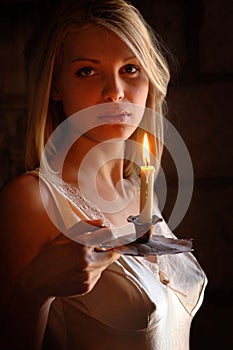 Beautiful young blonde girl with a candle