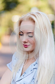 Beautiful young blonde girl with a pretty face and beautiful smiling eyes. Portrait of a woman with long hair and amazing looks.