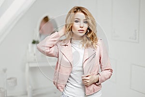 Beautiful young blonde girl in stylish leather jacket posing
