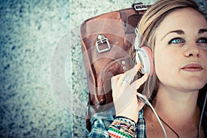 Beautiful young blonde hipster woman listening music