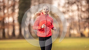 A beautiful young blonde in sportswear is training for running in the park