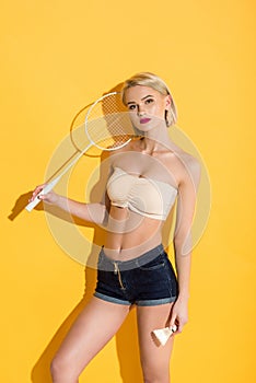 beautiful young blonde woman with badminton racket and shuttlecock looking at camera photo