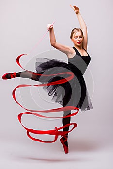 Beautiful young blonde woman ballet gymnast training calilisthenics exercise with red ribbon with red shoes