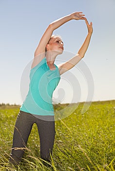 Beautiful young blonde woman exercising in the outdoors yoga ph