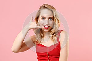 Beautiful young blonde woman girl in red sexy clothes posing isolated on pastel pink background studio portrait. People