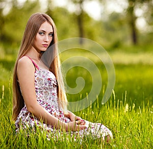 Beautiful young blonde woman on the meadow