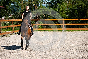 Beautiful young blonde woman riding a horse