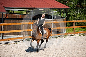 Beautiful young blonde woman riding a horse