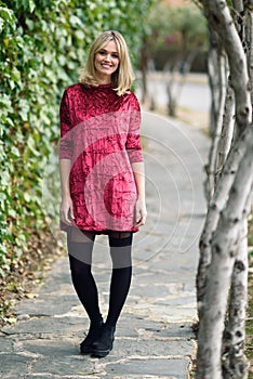 Beautiful young blonde woman smiling in urban background