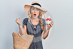 Beautiful young blonde woman wearing summer style eating ice cream afraid and shocked with surprise and amazed expression, fear