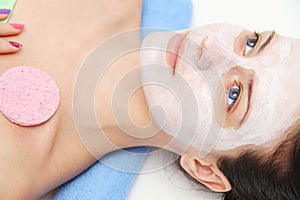 Beautiful young blue eye woman with clay facial mask