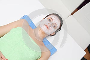 Beautiful young blue eye woman with clay facial mask