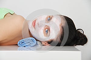 Beautiful young blue eye woman with clay facial mask