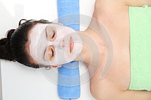 Beautiful young blue eye woman with clay facial mask