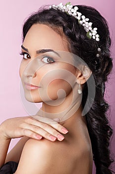 Beautiful young bride with a floral ornament in her hair.Beautiful Woman Touching her Face. Youth and Skin Care Concept.Nymph.