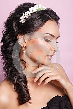 Beautiful young bride with a floral ornament in her hair.Beautiful Woman Touching her Face. Youth and Skin Care Concept.Nymph.