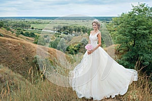 Beautiful young bride girl smiling, standing in wedding dress.