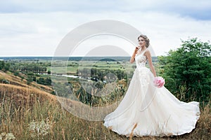 Beautiful young bride girl smiling, standing in wedding dress.