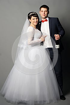 Beautiful young bride and groom posing at studio