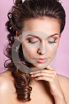 Beautiful young bride ith a floral ornament in her hair.Beautiful Woman Touching her Face. Youth and Skin Care Concept