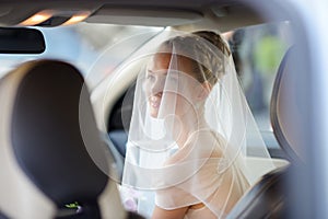 Beautiful young bride portrait in a car